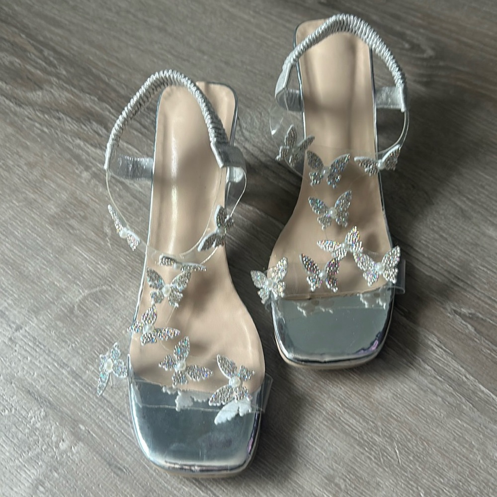 Women’s size 9 butterfly clear acrylic heels with elastic straps.